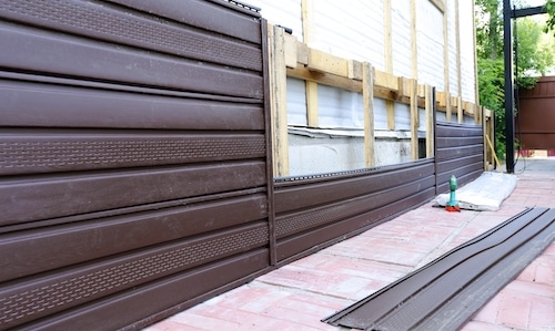 Installation of brown plastic siding on the facade of the house